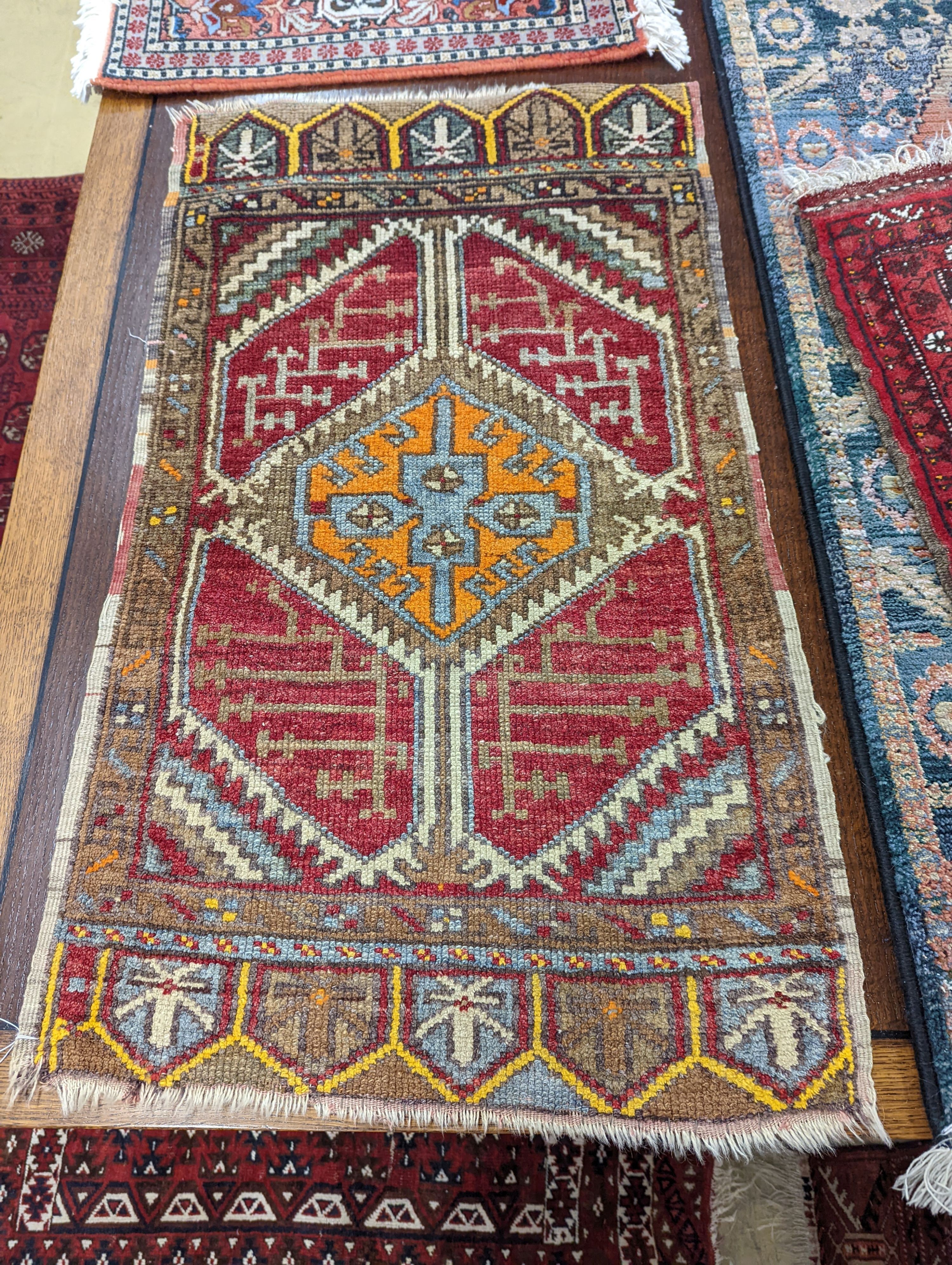 A Caucasian red ground mat, a Bokhara mat, three others and a blue ground rug, largest 136 x 80cm (6)